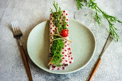 Rustic table setting for Christmas dinner of dotted napkin with branch