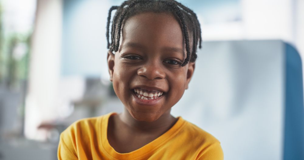 Boy Sitting In The Chair In Hospital, Looking At Camera And Smiling.