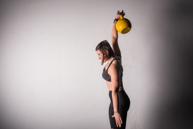 woman lifting kettlebell in gym
