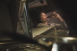 Reflection of woman drinking from bottle