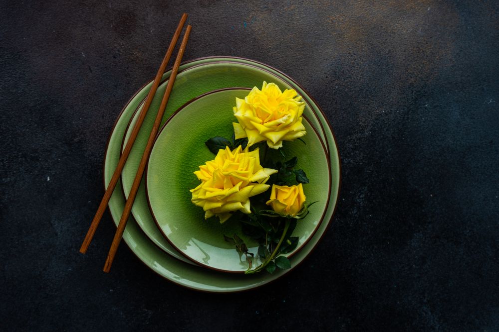 Top view of green table setting with yellow roses