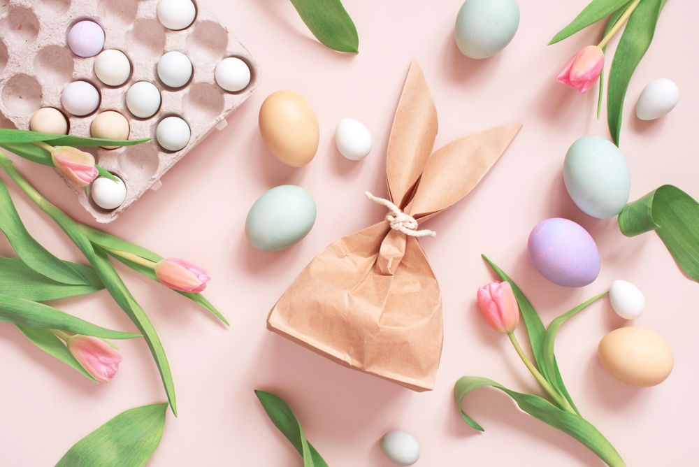 Top view of Easter eggs, tulips and paper bag in rabbit ear shapes