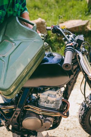Man refilling the gas tank of a motorbike