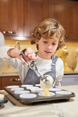Boy pouring batter into baking tray