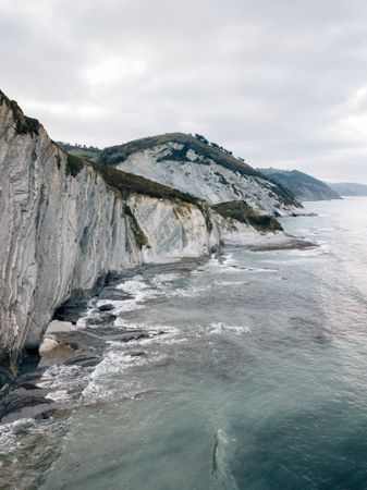Sea waving near green hills