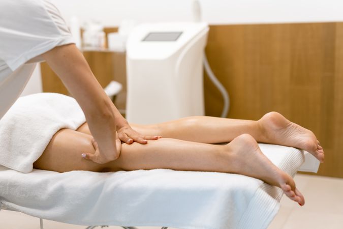 A female’s legs being massaged by a masseuse