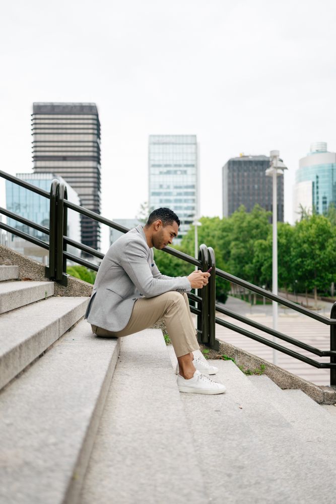 Man sitting on stairs using smartphone