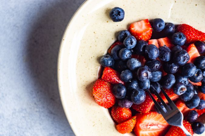 Ripe organic berries on cream plate