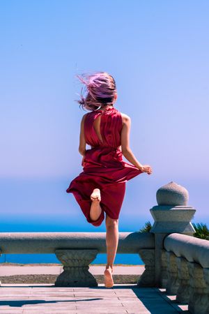Woman in red jumping in summer