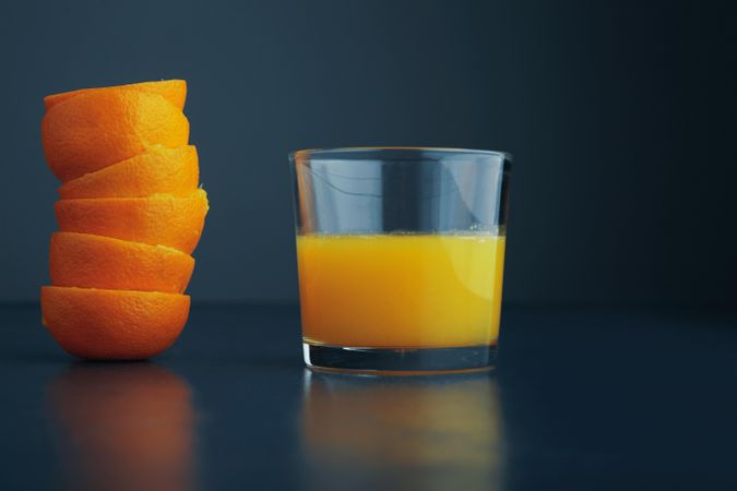 Glass of fresh juice with stack of freshly squeezed tangerine