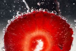 Slice of strawberry covered with bubbles