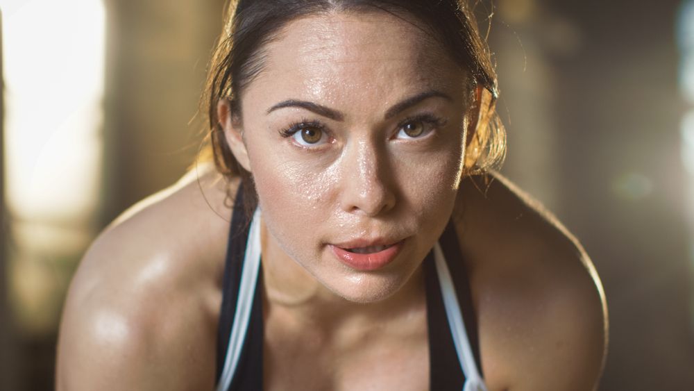 Shot of a Athletic Brunette Resting on the Bench and Smiling into the Camera.