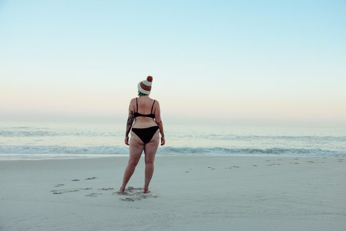 Unrecognizable female winter bather standing at the beach in swimwear