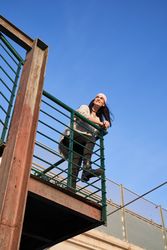 Smiling woman in pink scarf on grunge balcony