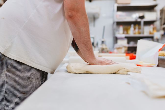 Unrecognizable cook kneading dough