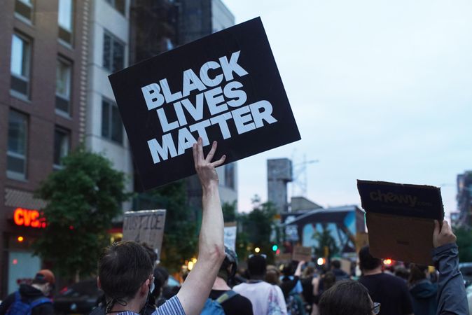 Person holding "Black Lives Matter" banner at BLM protests in New York, USA