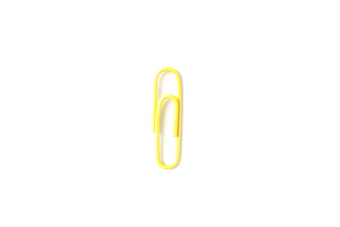Color paper clip isolated on plain background, closeup
