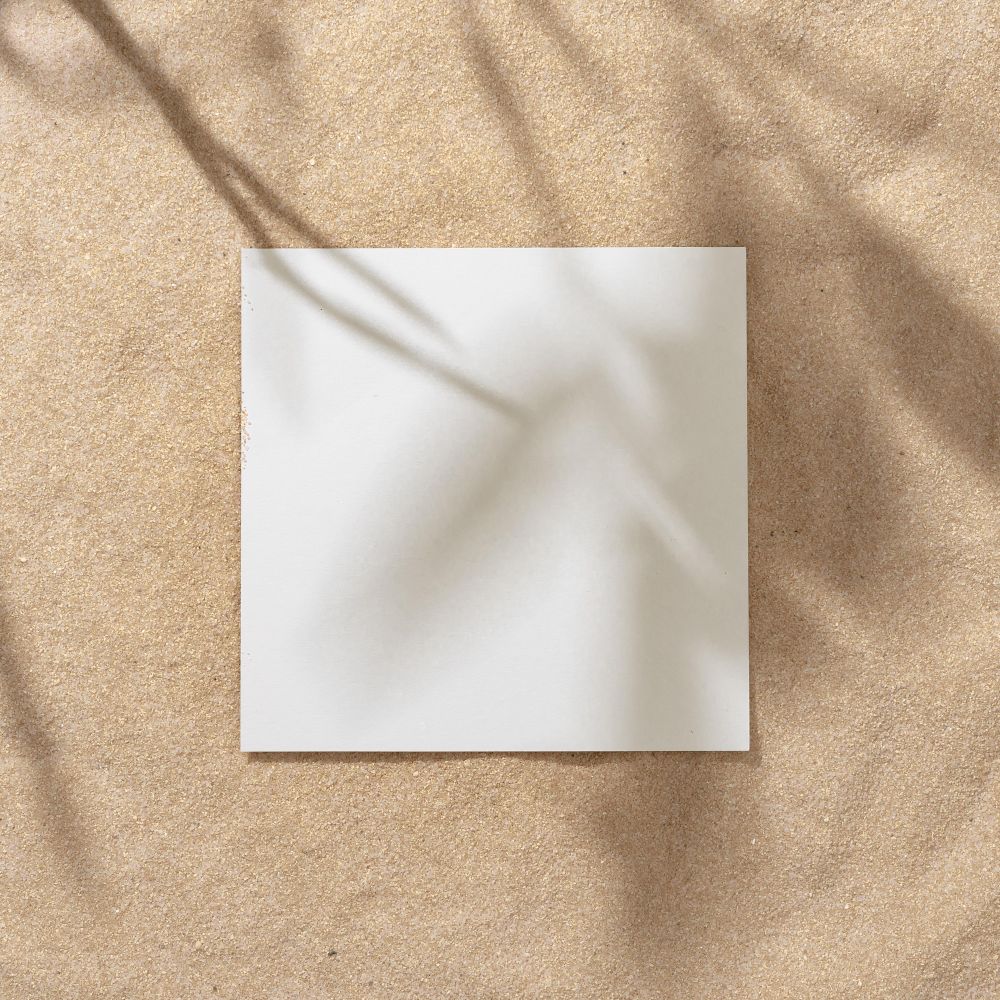 Sand with palm leaf shadows and central square