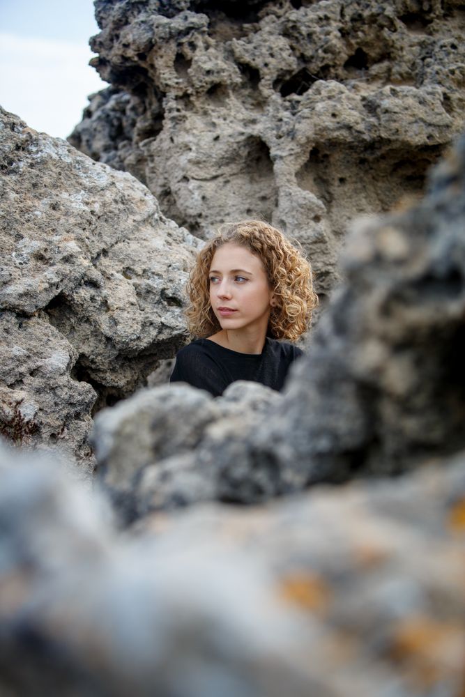 Young woman sitting between stones