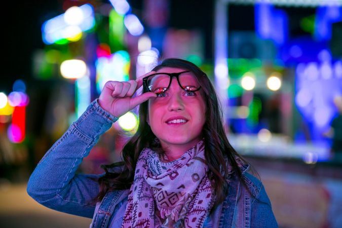 Stylish young woman near illumination on street