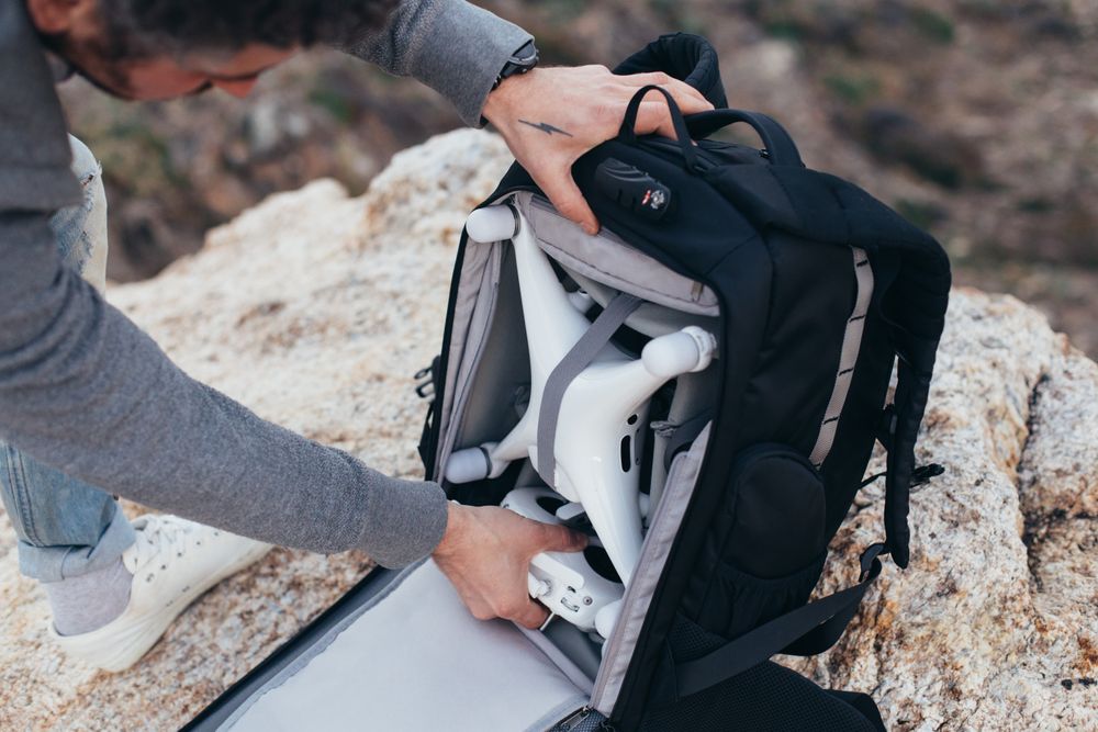 Man unloading backpack with equipment for aerial photography