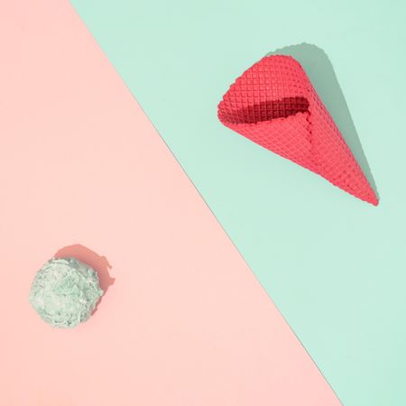 Ice cream cone with scoop of ice cream on pastel pink and blue background