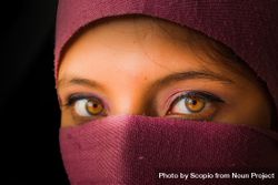 Woman showing her eyes behind purple fabric 0LpXP0