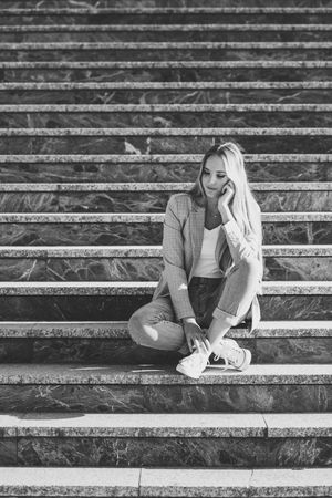 Woman sitting on steps in contemplation in b&w