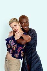 Photo of joyful females embracing dressed in casual jumpers