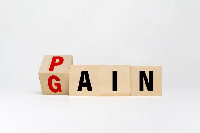 flip wooden blocks with pain and gain words isolated on blank background
