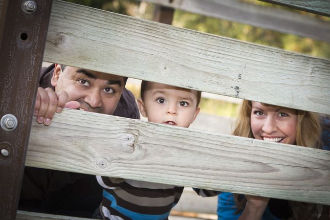 Happy Young Family Looking Through Fence