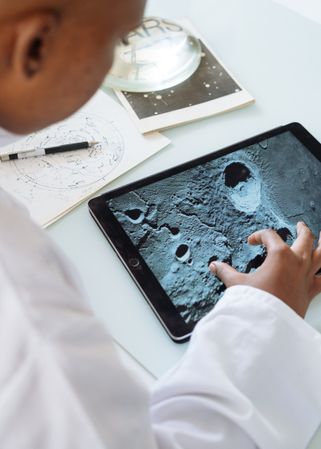 Close-up shot of young child using a tablet computer to see the moon's crater