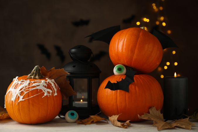 Halloween concept with pumpkins on brown background with blurred lights
