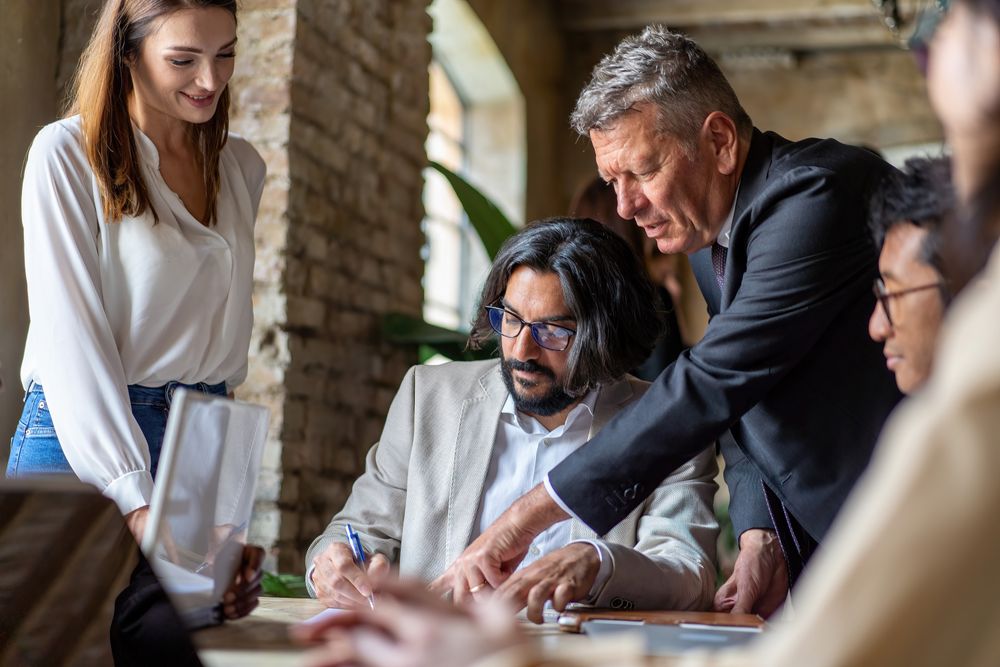 Diverse team signing a professional agreement in a modern office