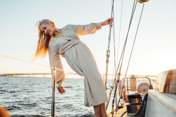 Older woman leaning off side of a yacht