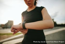 Close up shot of young woman runner using smartwatch outdoors 5Q3qNb