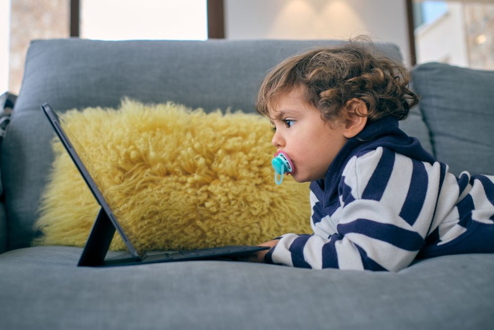 Little boy watching interesting cartoon at home