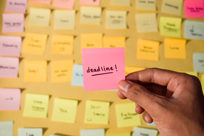 Hand hold sticky notes with words Deadline