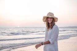 Charming woman in light white dress on wavy beach