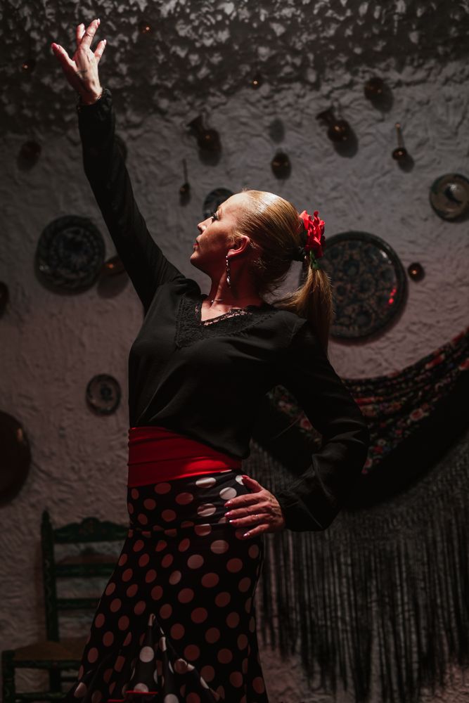 Woman dancer in flamenco costume standing in dance posture