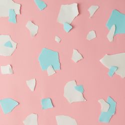 Pieces of ripped pastel colored paper in pattern