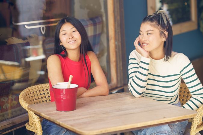 Two women sitting in restaurant patio waiting for their order