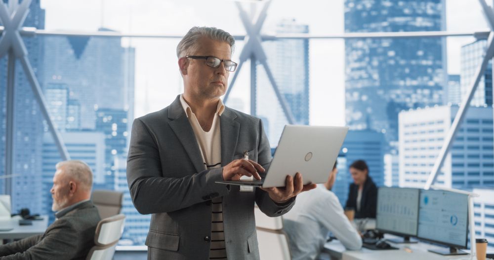 Successful Businessman Walking In Modern Office With Diverse Employees