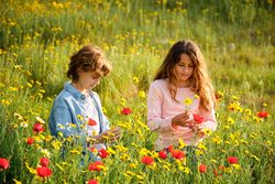 Children picking flowers in grassy meadow