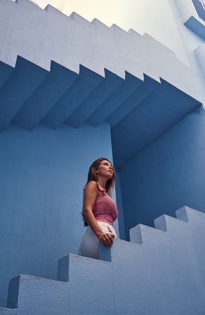 Woman walking upstairs on modern blue building