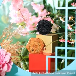 Two Chinese mooncakes surrounded by vibrant flowers 48mjYb