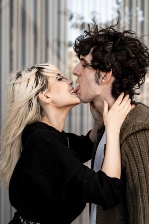 Happy loving couple having fun while kissing on street