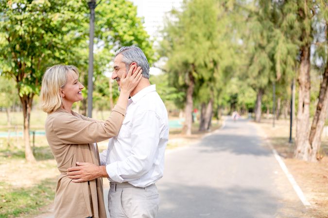 Happy older couple embracing in public park