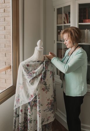 Dressmaker adjusting apparel on mannequin