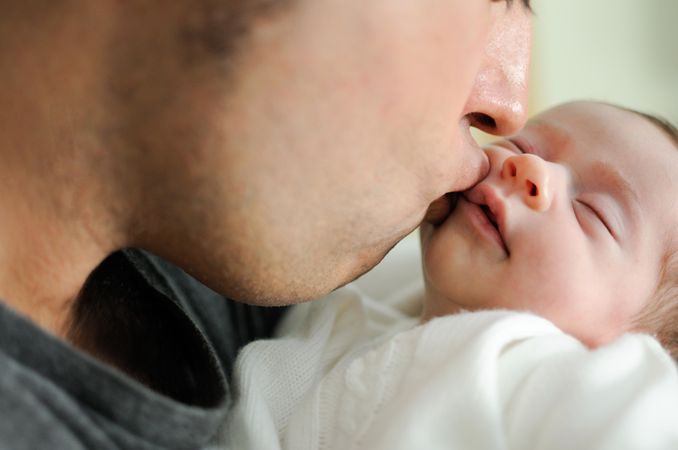 Dad kissing infant